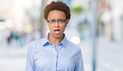 Young beautiful african american business woman over isolated background In shock face, looking skeptical and sarcastic, surprised with open mouth