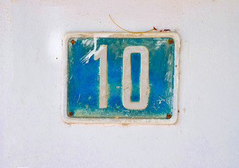 Number 10 / ten, rustic plate blue number on the wall.