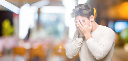 Young handsome man over isolated background with sad expression covering face with hands while...