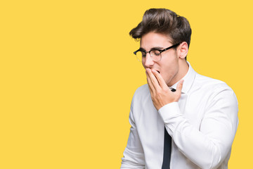 Young business man wearing glasses over isolated background bored yawning tired covering mouth with hand. Restless and sleepiness.