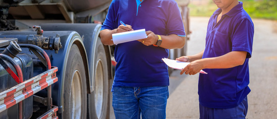 Truck drivers hand holding clipboard Check the product list,Preforming a pre-trip inspection on a truck,spot focus.