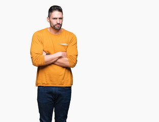 Young handsome man over isolated background skeptic and nervous, disapproving expression on face with crossed arms. Negative person.