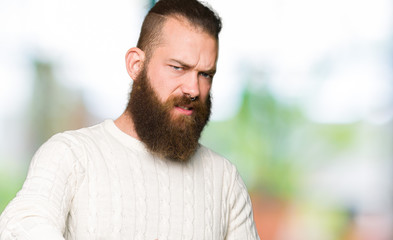 Obraz premium Young hipster man wearing winter sweater disgusted expression, displeased and fearful doing disgust face because aversion reaction. With hands raised. Annoying concept.