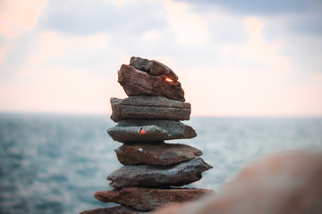 A stack of round stones standing on the shore of a sea Rocky coast at Khao Laem Ya Mu Ko Samet National Park Rayong, Thailand in sunset time