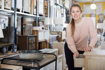 Female standing near commode in the furniture shop