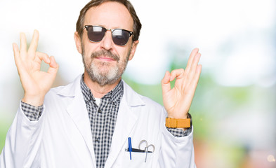 Naklejka premium Handsome middle age doctor man wearing sunglasses relax and smiling with eyes closed doing meditation gesture with fingers. Yoga concept.