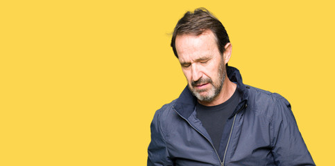 Obraz premium Middle age handsome man wearing a jacket with hand on stomach because indigestion, painful illness feeling unwell. Ache concept.