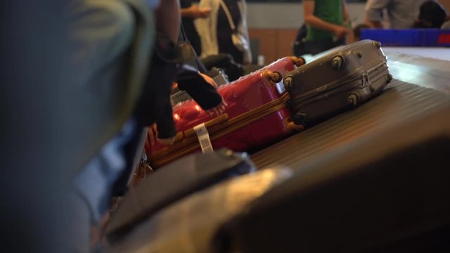 People are claiming their baggages on conveyor belt