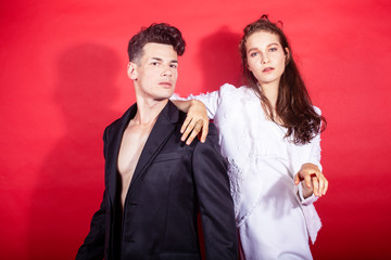 young fashion style couple man and woman on red sexy background, luxury stuff, lifestyle modern people sale concept
