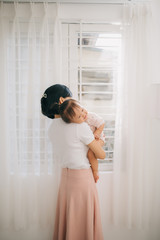 Portrait of happy vietnamese mother hugging with her cute little daughter at home
