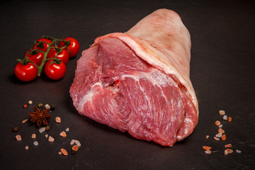 large raw leg with meat with spices tomatoes cherry