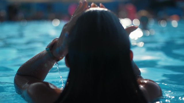 Thrilling summer footage of sexy young fit girl in the clear blue pool emerges from the water in Slow motion
