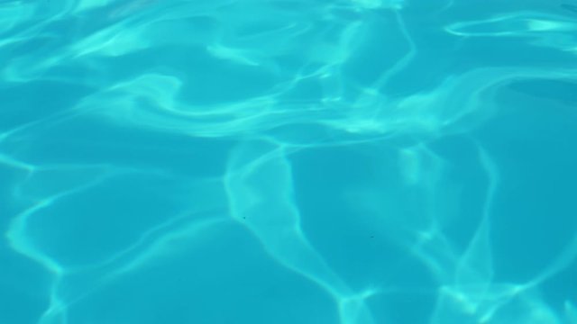 Good view of a clear blue tranquil water in a pool. Summer background of a water in Slow motion