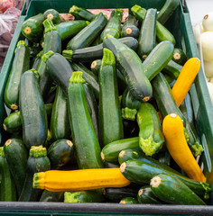 Tub of green and yellow Zucchini for sale at the local farmer’s market