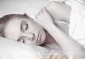 Fototapeta na wymiar Sleep. Blur background. Beautiful young woman sleeping in bed. Morning dream. Attractive girl resting in a comfortable bed on a pillow. Bedroom. Close up. Copy space for your text.