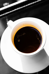 Double espresso in cup on glass table