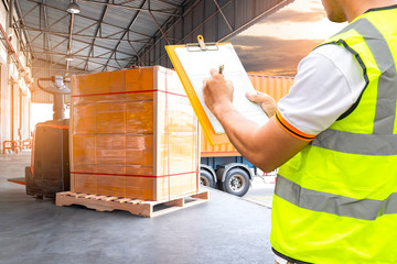 Worker Courier Holds a Clipboard Controlling the Loading of Packaging Boxes into Shipping...