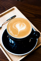 Hot latte coffee serve in dark blue cup with love latte art