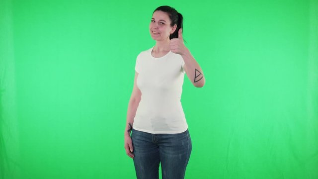 Cheerful woman in white t-shirt show thumbs up gesture green screen background
