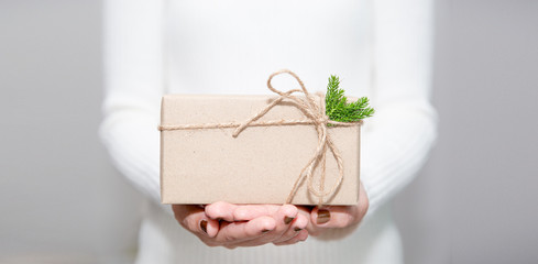 Woman hands with white sweater holding a diy gift box for special event with copy space.