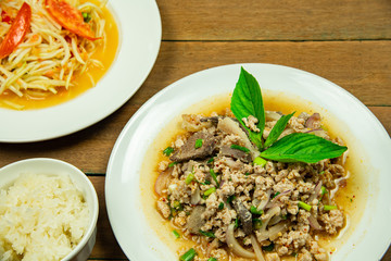 Most popular Thai northeast food with papaya salad and minced pork liver salad with sticky rice on wooden table background.