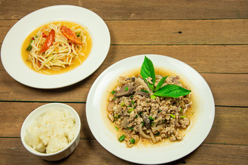 Most popular Thai northeast food with papaya salad and minced pork liver salad with sticky rice on wooden table background.