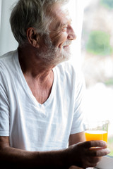 Happy senior man portrait. Bearded man. Holding orange juice, happy smile.