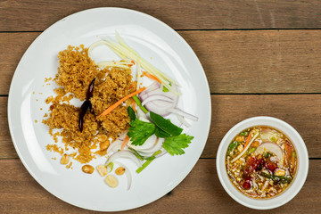 Delicious fluffy deep fried catfish on white dish with spicy mango sauce on wooden table background.