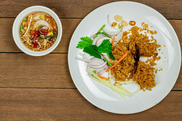 Delicious fluffy deep fried catfish on white dish with spicy mango sauce on wooden table background.