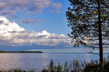 Evening water landscape of Lake Onega against the sky with clouds