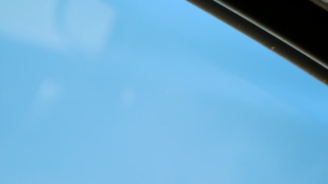 Bug flying away from a car window. Nice blue sky on the background.