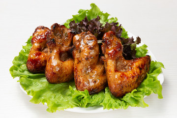 fried chicken wings with a plate, on a lettuce leaf, in sweet sauce
