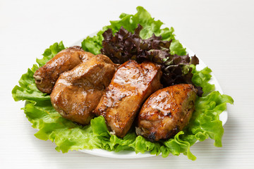 several pieces of grilled meat, on a lettuce, beef or pork skewers