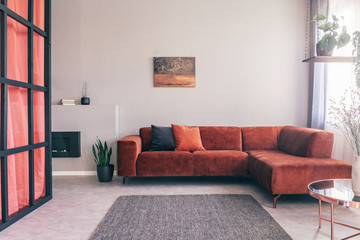 Cozy living room interior with corner sofa with pillows and painting on the wall