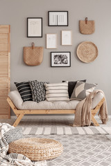 Beige scandinavian settee with patterned pillows in stylish living room interior