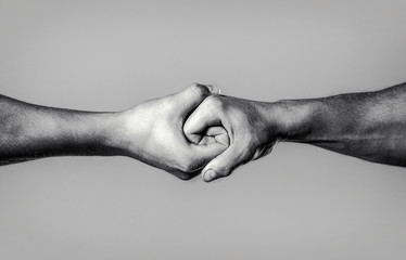 Two hands, isolated arm, helping hand of a friend. Rescue, helping hand. Male hand united in handshake. Man help hands, guardianship, protection. Black and white - obrazy, fototapety, plakaty