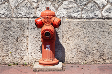 Fototapeta na wymiar Closeup typical red fire hydrant on street, outdoor. Plumbing for fire hydrant on public footpaths