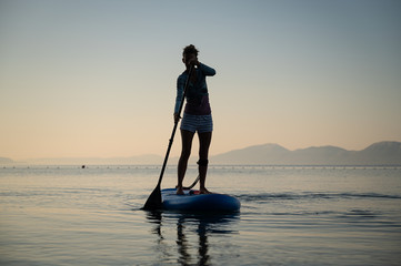 Young woman paddling on a sup board