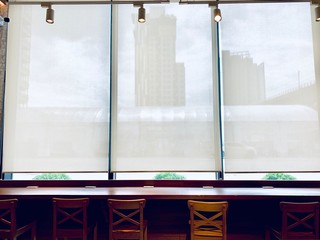 Modern blinds traditional home decoration. Sunlight coming through blinds by the window. Curtain at a window overlooking the highest Building of downtown outside.