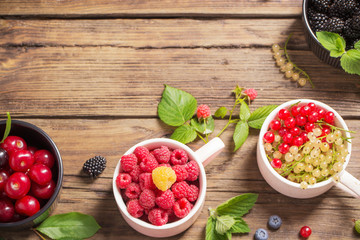 different berries on old wooden background