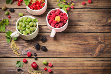 different berries on old wooden background
