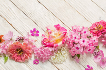 Fototapeta na wymiar pink flowers on white wooden background