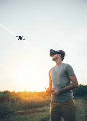 Drone pilot using drone with remote controller and virtual reality headset for making photos and videos