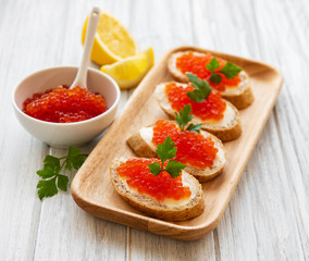 Red caviar in bowl and sandwiches