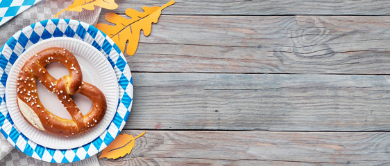 Oktoberfest, flat lay on rustic wooden table with pretzel and Autumn decorations