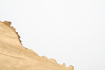 Cropped shot of aged effect beige paper piece with burnt edge on white background. Copy space.