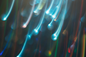 Neon multicolor glowing lines. Defocused falling blue sparks. Dark abstract art background.