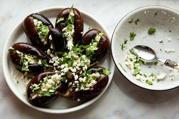 Baked eggplant on a white dish. Stuffed with Cheese and Greens