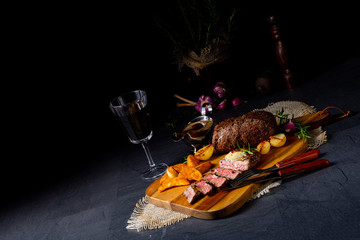 rustic medium butter beef steak with herbs and potato wedges