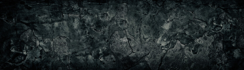 Wide weathered cracked black concrete wall. Black broken cement surface texture. Dark gloomy grunge background